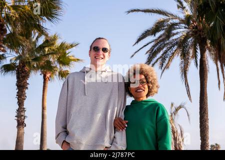 portrait d'un jeune couple heureux souriant bras dans le bras Banque D'Images