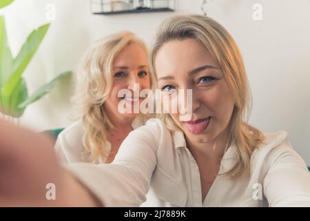 Jeune fille millénaire souriante Prenez le selfie avec une mère âgée amusante et joyeuse à la maison. Bonne fille adulte adulte. Amusez-vous à réaliser un autoportrait avec une mère mature, détendez-vous le week-end. Photo de haute qualité Banque D'Images