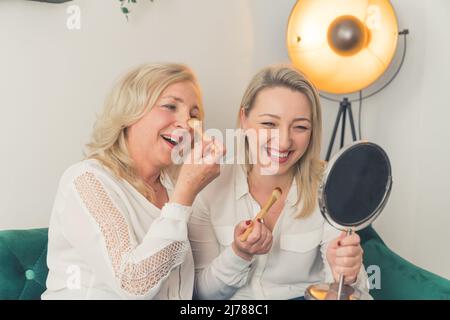 Jeune fille millénaire souriante avec une mère âgée amusante et amusante à la maison, bonne fille adulte adulte s'amuse à se faire masser avec sa mère, se détendre ensemble le week-end. Photo de haute qualité Banque D'Images