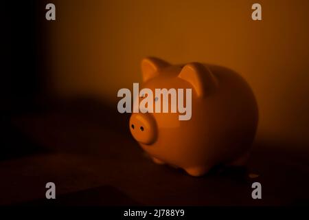 Tirelire. Figure de cochon pour l'argent de pliage. Symbole du bien-être financier. La figure de l'animal est en porcelaine. Objet sur table. Banque D'Images