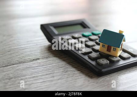 Maison de jouets et calculatrice avec espace de copie. Propriété, assurance habitation, acheter, vendre et louer concept. Banque D'Images