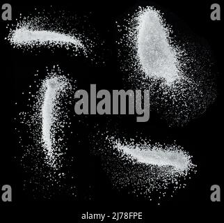 Cristaux de sucre blanc raffiné tombant sur fond noir. Banque D'Images