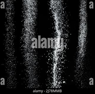 Cristaux de sucre blanc raffiné tombant sur fond noir. Banque D'Images