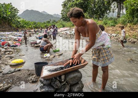 Femmes et filles lavant des vêtements dans la rivière près de la ville de Neves. Banque D'Images