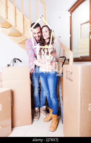 un jeune couple entre dans une nouvelle maison Banque D'Images