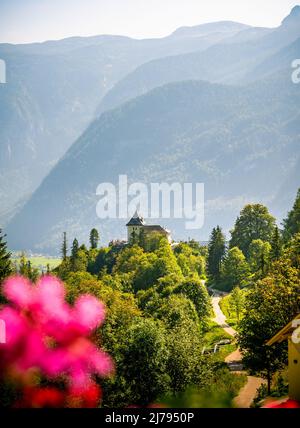 Vue panoramique de la célèbre vieille ville de Hallstatt et lac alpin bleu profond avec bateau touristique dans la lumière du matin dorée pittoresque lors d'une belle journée ensoleillée au soleil Banque D'Images