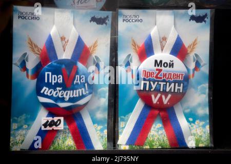 Moscou, Russie. 7th mai 2022. Gros plan sur les badges patriotiques en vente dans une fenêtre de kiosque dans le centre de Moscou, en Russie. L'inscription sur les badges indique « la vérité va gagner ! » (L) et « mon président Poutine V.V » (R). Les lettres Z et V utilisées par les forces russes comme symbole d'identification sur leurs véhicules lors d'opérations spéciales en Ukraine Banque D'Images