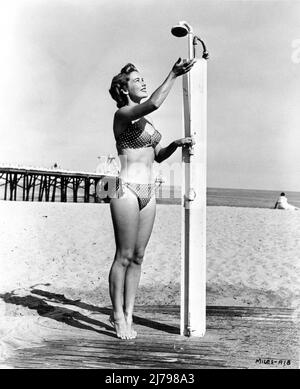 VERA MILES vers 1956 pose dans le bikini ayant une douche sur la Californie publicité de plage pour Warner Bros. Banque D'Images