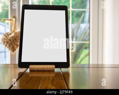 Tablette électronique avec écran vierge et support sur fond plat en chêne Banque D'Images