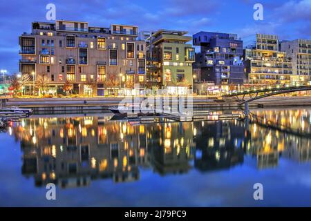 Scène nocturne avec des bâtiments résidentiels modernes sur un petit canal dans le quartier postmoderne de la Confluence à Lyon, France Banque D'Images