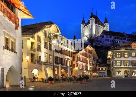 Rathausplatz (place de l'hôtel de ville) à Thun, canton de Berne, Suisse de nuit, avec le côté blanc du château de Thun donnant sur la scène Banque D'Images