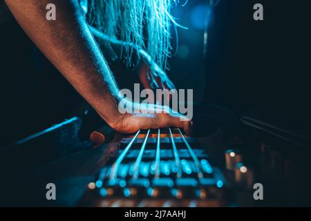 Des mains de sexe masculin saisissant pour cinq guitares basses électriques à cordes dans un suitecase Banque D'Images