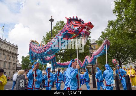 7 mai 2022, Londres, Angleterre, Royaume-Uni: Les praticiens portent un dragon à Whitehall. Les pratiquants de Falun Dafa (également connu sous le nom de Falun Gong) ont défilé dans le centre de Londres jusqu'à Downing Street à l'occasion du 30th anniversaire de la fondation du mouvement, pour célébrer la pratique et sensibiliser les pratiquants à la persécution des pratiquants en Chine. Falun Gong combine méditation et exercices de Qigong avec philosophie morale, et a été soumis à une répression continue par le Parti communiste chinois. (Image de crédit : © Vuk Valcic/ZUMA Press Wire) Banque D'Images