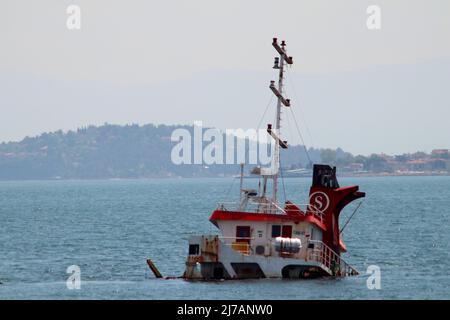 Un navire rouge a chaviré dans une tempête au large de la côte de Maltepe (Istanbul) avec les îles Princes dans la mer de Marmara en arrière-plan Banque D'Images