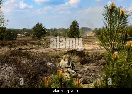 Un soldat américain affecté au bataillon 1st, 8th Infantry Regiment, 3rd Armored Brigade combat Team, 4th Infantry Division, assure la sécurité tandis qu'un véhicule de combat M2A3 Bradley s'engage avec une cible lors d'un exercice dans la zone d'entraînement d'Oberlaussitz, en Allemagne, le 3 mai 2022. L'équipe de combat de la Brigade blindée de 3rd, division d'infanterie de 4th, est parmi les autres unités affectées au V corps, le corps de déploiement avancé des États-Unis en Europe qui travaille aux côtés des alliés de l'OTAN et des partenaires de sécurité régionaux pour fournir des forces crédibles au combat. (États-Unis Garde nationale de l'armée photo par le sergent d'état-major. Gabriel Rivera) Banque D'Images