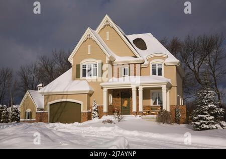 Moderne rouge nuancé brique et beige bois planche a ajouté deux étages maison de style cottage de campagne en hiver. Banque D'Images