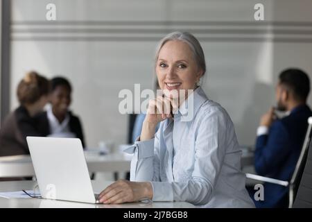 Bonne femme d'affaires mûre dans le bureau ouvert en milieu de travail photo tête portrait Banque D'Images