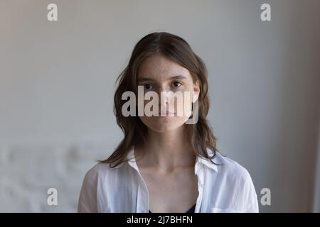 Sérieuse jolie petite femme à l'avant de la tête tourné en intérieur portrait Banque D'Images