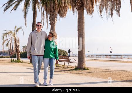 jeune couple souriant heureux en marchant Banque D'Images