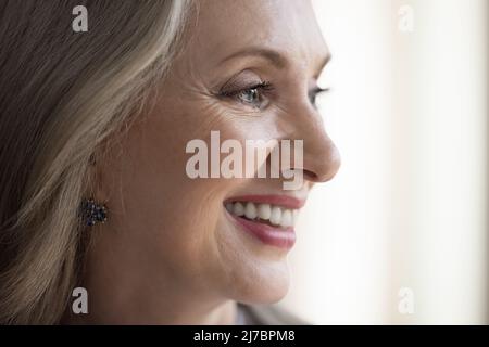 Bonne rêverie mûre gris cheveux visage de dame avec maquillage Banque D'Images