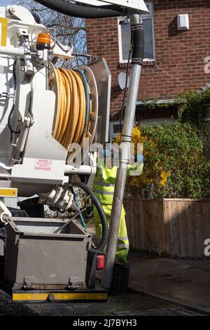 Un homme arrive avec un camion à vide pour aspirer les boues des drains municipaux. Concept - problèmes d'entretien et de drainage. Newcastle upon Tyne, Royaume-Uni. Banque D'Images