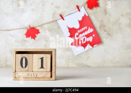 Calendrier en cube en bois avec date DU 1 JUILLET sur fond clair. Bonne journée du Canada Banque D'Images