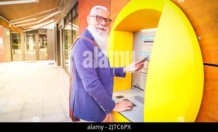 Homme senior avec ATM Banque D'Images