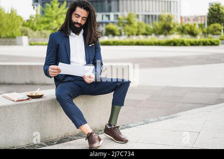 Homme d'affaires avec prothèse faisant une pause déjeuner à l'extérieur du bureau - Entrepreneur et handicap concept Banque D'Images