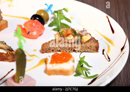 Canapés avec caviar rouge saumon sur fond en bois Banque D'Images