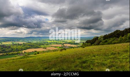 Vue sur la campagne à Blatchford Down, Abinger Hammer dans la région de Surrey Hills d'une beauté naturelle exceptionnelle, soleil dans la vallée, nuages sombres de tempête Banque D'Images