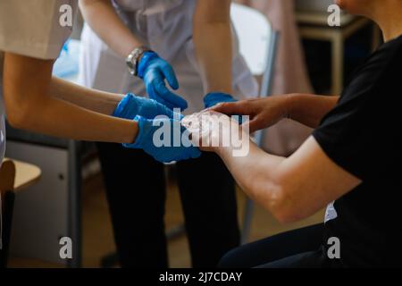 Détails avec les mains d'une femme médique et d'une femme résidente médique vérifiant la santé dermatologique d'une femme. Banque D'Images