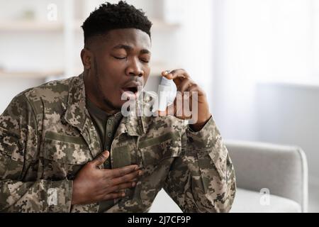 Soldat noir souffrant d'une attaque de panique, utilisant un inhalateur Banque D'Images