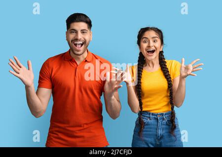 Émotions humaines. Portrait d'un jeune couple arabe surpris qui se répand les mains avec enthousiasme Banque D'Images