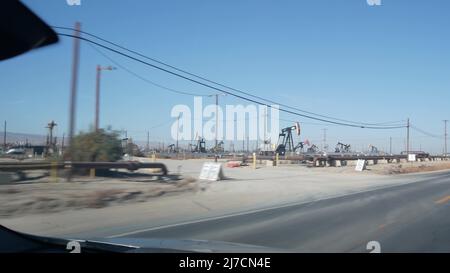 Puits avec vérins à pompe sur champ de pétrole, Californie, États-Unis.Plates-formes d'extraction de fossiles bruts travaillant sur les champs pétrolifères.Paysage industriel, derricks dans la vallée du désert.De nombreuses plates-formes de citrouilles sur le pompage des puits d'huile. Banque D'Images