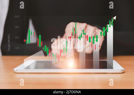 croissance boursière en hausse. Homme d'affaires tient une tablette et affiche un graphique holographique montrant les statistiques des graphiques rentables. Idées de planification de la croissance et Banque D'Images