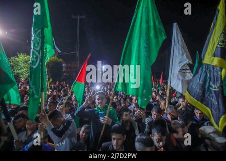 Gaza, Palestine - 07 mai 2022, les partisans du Hamas branlent les drapeaux tout en marchant vers le domicile du chef du Hamas Yahya Sinwar pour promettre leur allégeance aux dirigeants de la résistance et en réponse aux menaces israéliennes. L'armée israélienne a transmis un message au Hamas à Gaza qu'elle avait pris la décision de liquider Yahya Sinwar. Banque D'Images