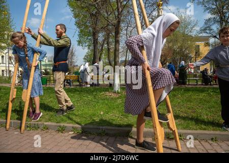 Moscou, Russie. 8th mai 2022. Les enfants marchent sur des pilotis dans une rue dans une baratte de l'église de l'intercession de notre Dame Reine à Rogozhskaya Old-Rite Sloboda pendant la fête des Saints Myrrhbearers à Moscou, Russie Banque D'Images