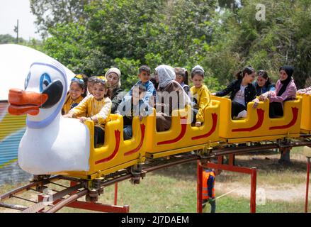 Les Palestiniens profitent d'une balade dans le parc d'attractions pendant les vacances d'Eid al-Fitr marquant la fin du mois Saint du Ramadan à Khan Yunis, dans le sud de Gaza. (Photo de Yousef Masoud / SOPA Images/Sipa USA) Banque D'Images