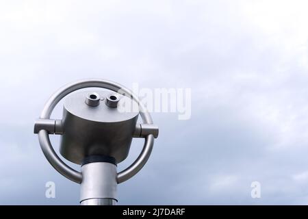 vue rapprochée d'en dessous sur un télescope fixe à un point de vue devant un ciel nuageux Banque D'Images