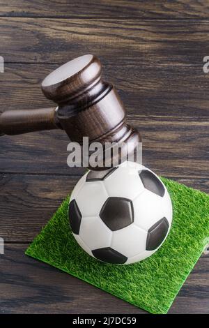 Le gavel du juge en bois et le ballon de football sur l'herbe. Sanctions des organisations de football concept Banque D'Images