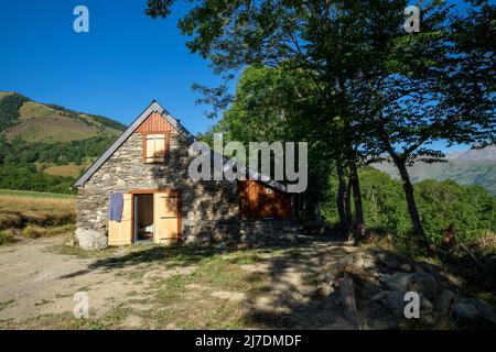 Authentique grange pyrénéenne rénovée dans la vallée de l'Aure. Toit en ardoise, construction en pierre et bois exposés. Vue imprenable sur les montagnes Banque D'Images