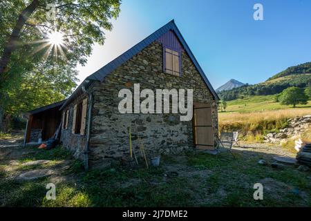 Authentique grange pyrénéenne rénovée dans la vallée de l'Aure. Toit en ardoise, construction en pierre et bois exposés. Vue imprenable sur les montagnes Banque D'Images