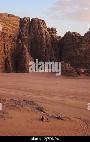 Touristes attendant le coucher du soleil dans le désert de Wadi Rum en Jordanie Banque D'Images