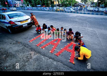 Kolkata, Inde - 8 mai 2022, les enfants éclaient les bougies autour du mot « MAA » qui, au Bengali, signifie que mère observe le jour des mères à Kolkata. Les activistes sociaux indiens ont démontré qu'ils sensibilisent l'opinion à la condition du sang et à la thalassémie, à l'occasion de la Journée internationale de la thalassémie qui partage une date avec la Fête des mères. La fête des mères est commémorée pour souligner l'existence des mères et leur importance dans la vie humaine. Banque D'Images