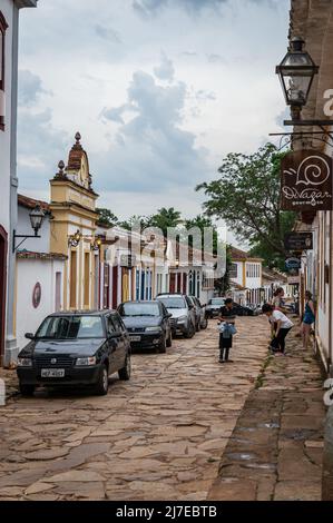 La rue Direita avec beaucoup de petites affaires fonctionnant dans le village des bâtiments coloniaux et beaucoup de voitures garées dans la rue dans le centre historique de Tiradentes. Banque D'Images