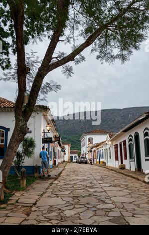 Rue Direita vue lointaine de nombreux bâtiments coloniaux des deux côtés dans le centre historique de Tiradentes. Vue depuis la place Rosario sous ciel nuageux. Banque D'Images