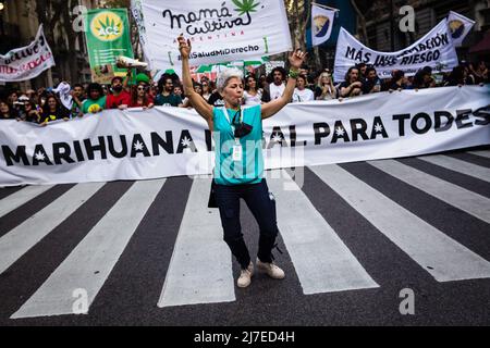 Buenos Aires, Argentine - 07 mai 2022, Une femme danse devant une bannière qui dit "la marijuana légale pour tous". Une foule de gens ont participé ce samedi au centre de la ville de Buenos Aires à une nouvelle édition de la Marche mondiale de la marijuana, qui se passe chaque année au niveau international, pour exiger la dépénalisation totale de la culture et de la consommation de cannabis. Banque D'Images