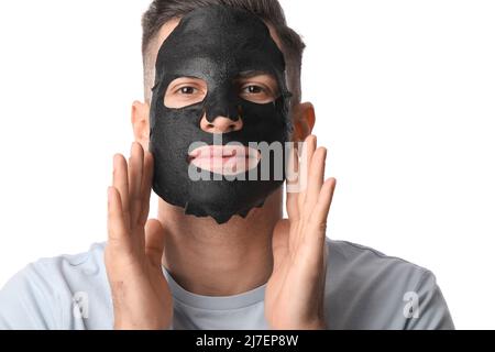 Beau homme avec masque noir sur fond blanc, gros plan Banque D'Images