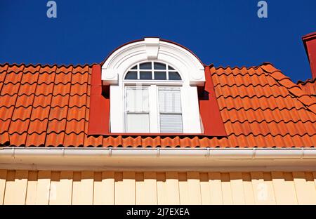 belle vieille fenêtre en bois blanc avec des carreaux rouges sur le toit Banque D'Images