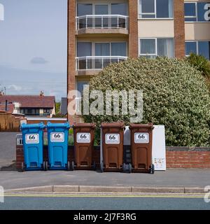 Des bennes à roulettes se trouvent à l'extérieur de la rue des appartements à St Annes, Lancashire, Royaume-Uni Banque D'Images